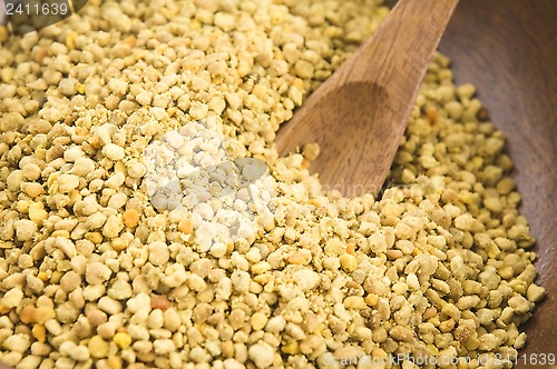 Image of Bee pollen in wooden scoop. Nutritional supplement