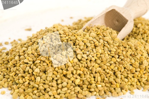 Image of Bee pollen in wooden scoop. Nutritional supplement