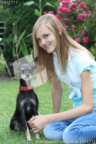 Image of Smiling teenage girl with her dog