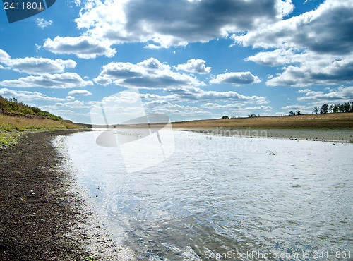 Image of green grass with river under cloudy sky