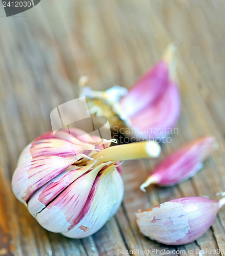 Image of red garlic bulb on old wood