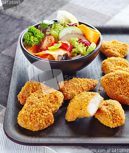 Image of chicken nuggets and fresh vegetable salad