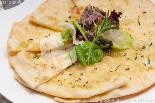 Image of garlic pita bread pizza with salad on top