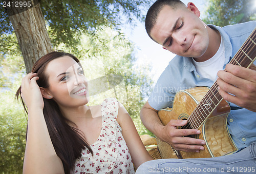 Image of Mixed Race Couple at the Park Playing Guitar and Singing