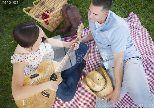 Image of Mixed Race Couple at the Park Playing Guitar and Singing
