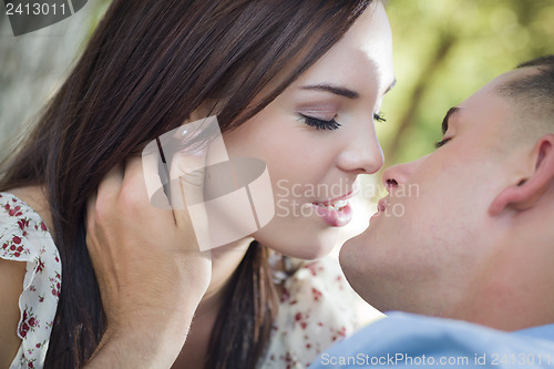 Image of Mixed Race Romantic Couple Kissing in the Park