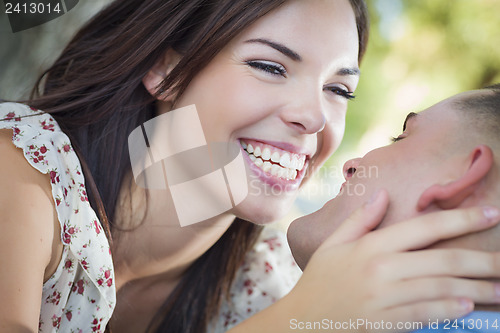 Image of Mixed Race Romantic Couple Kissing in the Park