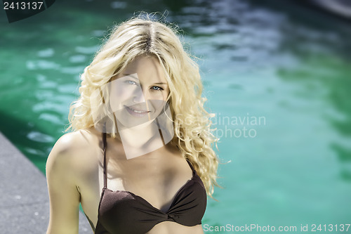 Image of Happy blond girl lying on pool