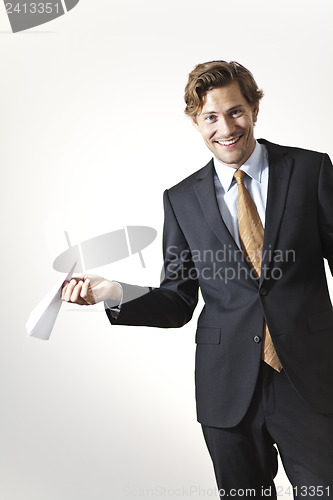 Image of Playfull businessman holding paper airplane