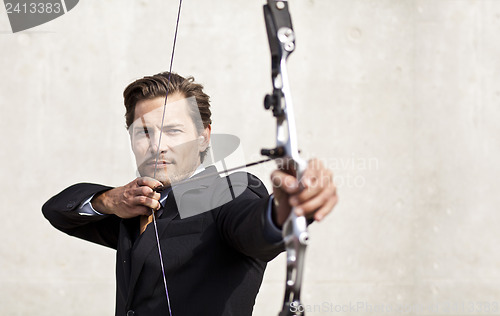 Image of Businessman aiming bow and arrow