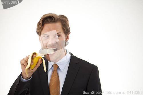 Image of Suspicious businessman eating banana