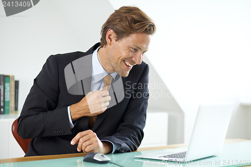 Image of Smiling businessman sitting at desk