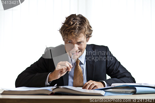 Image of Perplexed businessman working on problem