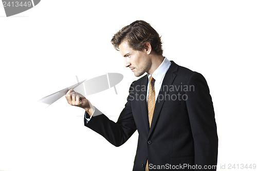Image of Concentrated businessman looking at paper airplane
