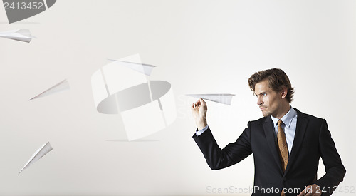 Image of Businessman throwing paper airplanes at target