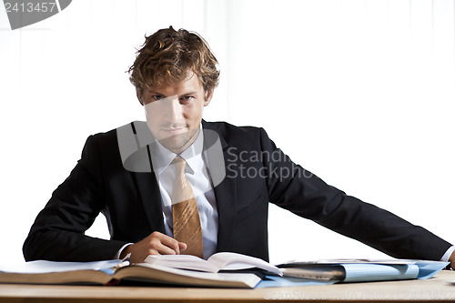 Image of Smart businessman sitting at desk