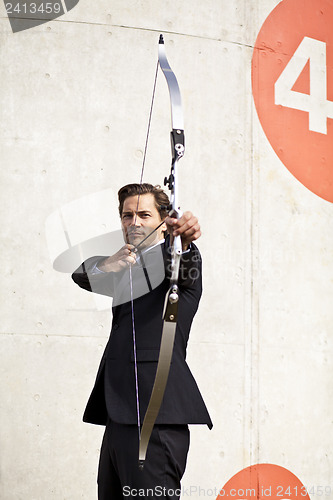 Image of Businessman aiming bow and arrow