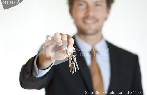 Image of Smiling businessman handing keys 