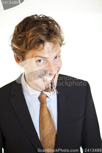 Image of Smiling businessman holding keys between his teeth