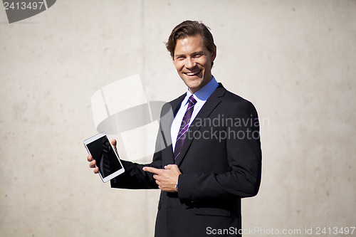 Image of Businessman pointing at tablet