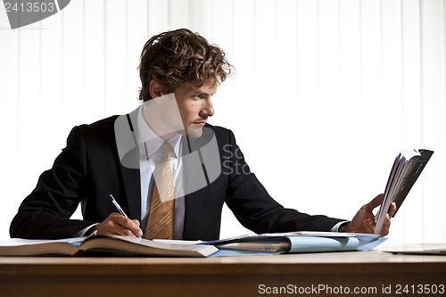Image of Hardworking businessman reading book