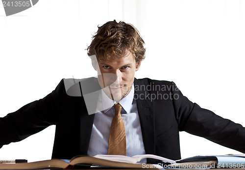 Image of Focused businessman sitting at desk