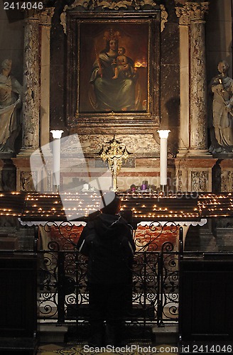 Image of Women pray at the altar of the Virgin Mary