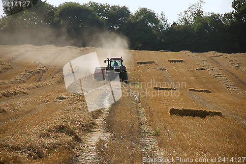 Image of Tractor and baler in a field at harvest time