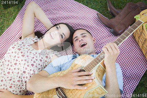 Image of Mixed Race Couple at the Park Playing Guitar and Singing