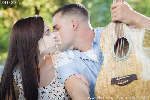 Image of Mixed Race Couple Portrait with Guitar in Park