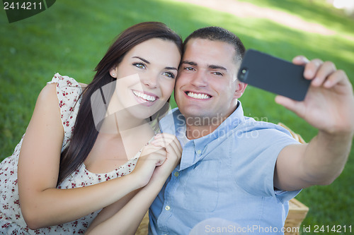 Image of Mixed Race Couple Taking Self Portrait in Park