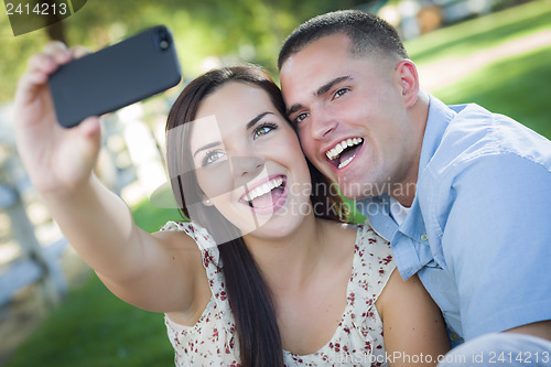 Image of Mixed Race Couple Taking Self Portrait in Park