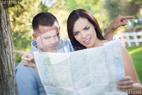 Image of Lost and Confused Mixed Race Couple Looking Over Map Outside