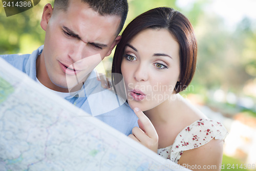Image of Mixed Race Couple Looking Over Map Outside Together