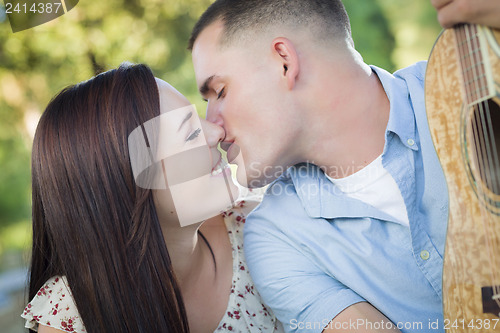 Image of Mixed Race Couple Portrait with Guitar in Park