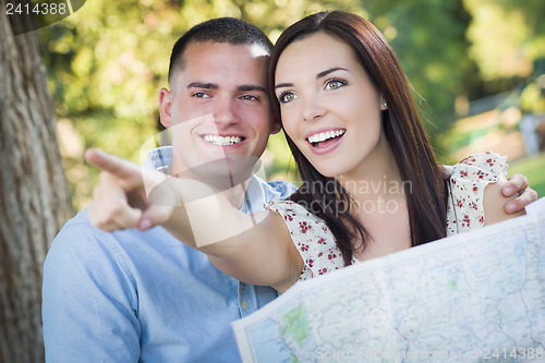 Image of Mixed Race Couple Looking Over Map Outside Together