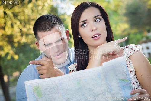 Image of Lost and Confused Mixed Race Couple Looking Over Map Outside