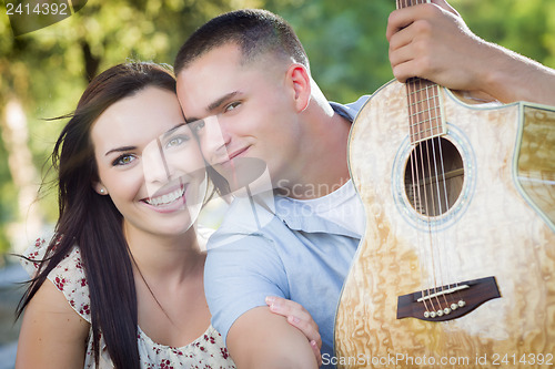 Image of Mixed Race Couple Portrait with Guitar in Park