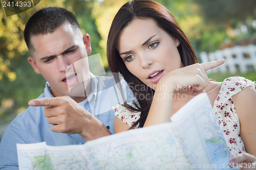 Image of Lost and Confused Mixed Race Couple Looking Over Map Outside