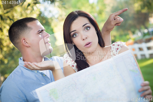 Image of Lost and Confused Mixed Race Couple Looking Over Map Outside