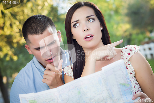 Image of Lost and Confused Mixed Race Couple Looking Over Map Outside