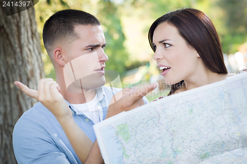 Image of Lost and Confused Mixed Race Couple Looking Over Map Outside