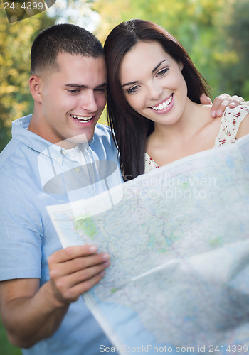 Image of Mixed Race Couple Looking Over Map Outside Together