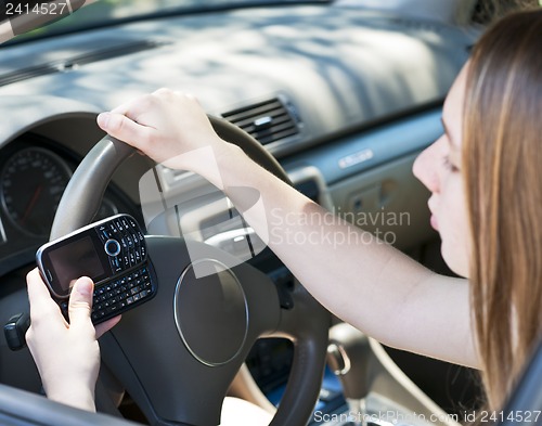 Image of Teenage girl texting and driving