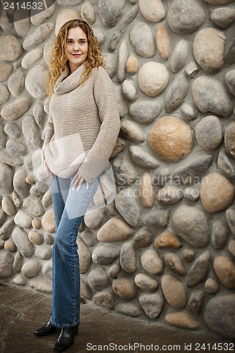 Image of Woman in front of stone wall