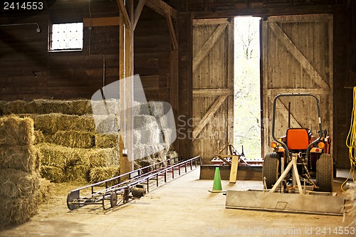 Image of Barn interior with hay bales and farm equipment
