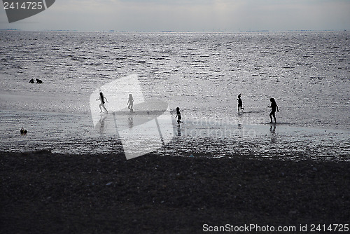 Image of Children playing at the beach in silhouette