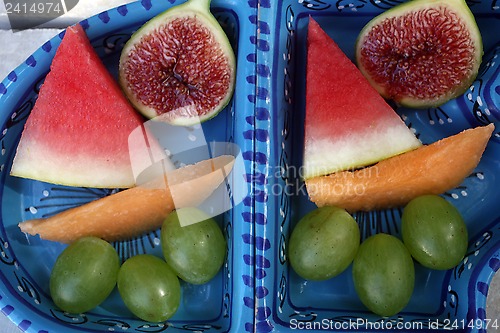 Image of Grapes, figs, watermelon and melon in a blue bowl