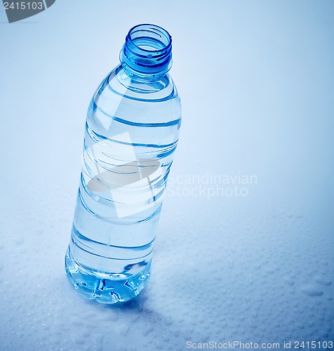 Image of plastic water bottle on wet blue background