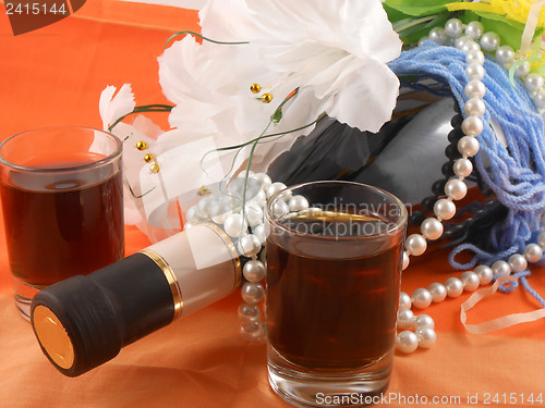 Image of two glasses, bottle of wine and white flowers. festive arrangement with sparkling champagne and flowers